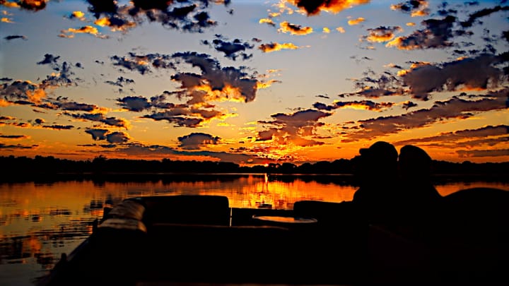 sky and water lit up by the sun just above the horizon. Vivid orange and clear reflections